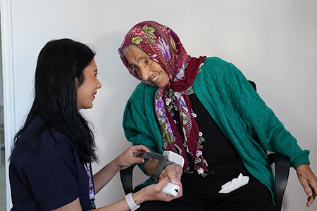 Retired senior man having health check with nurse at home